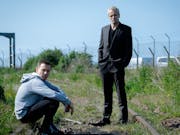 Two white middle aged men at an old railway track