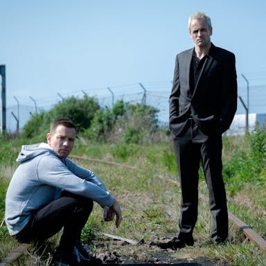 Two white middle aged men at an old railway track 