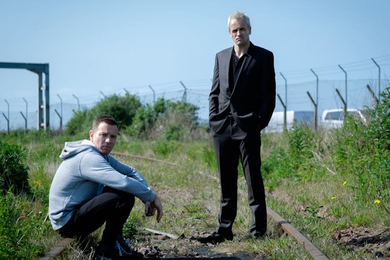 Two white middle aged men at an old railway track 