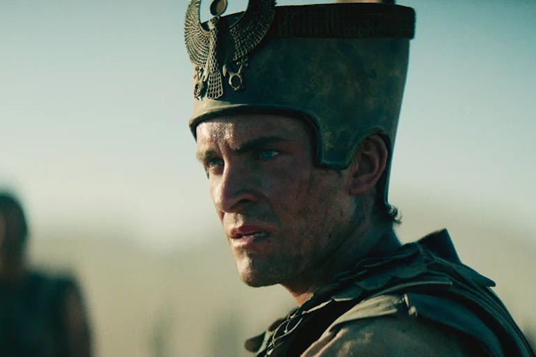 A white man with a sweaty dirty face in armour and a grand Egyptian helmet