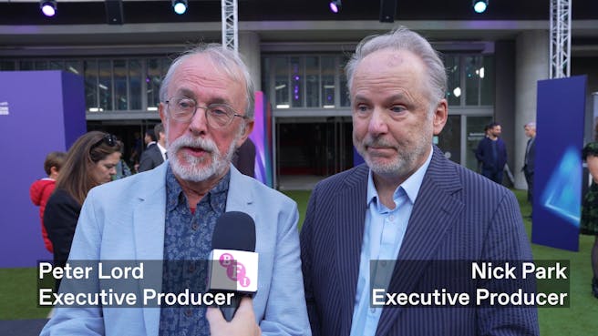 Two white men with grey hair and beards speaking into a mic