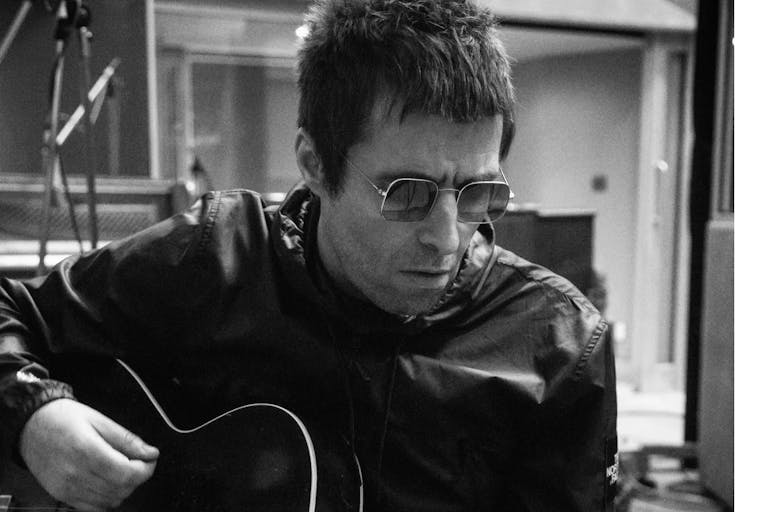 man in sunglasses plays an acoustic guitar