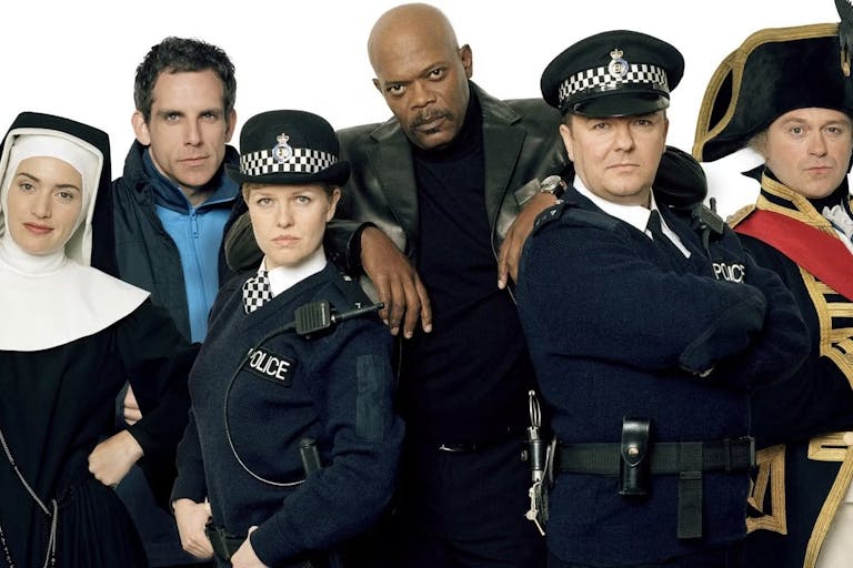 Two white women, one Black man and three white men stand in a line wearing various costumes; nun, police officers, admiral, etc.