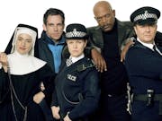 Two white women, one Black man and three white men stand in a line wearing various costumes; nun, police officers, admiral, etc.