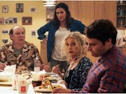 A white family sit around a dinner table eating Chinese food