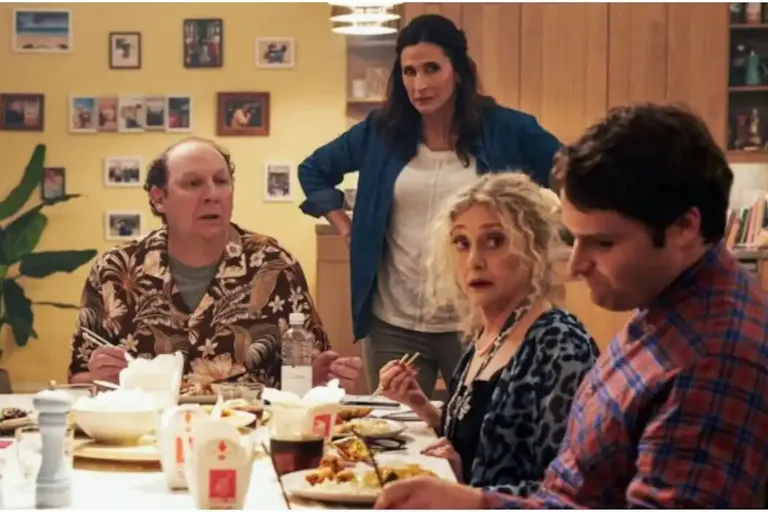 A white family sit around a dinner table eating Chinese food