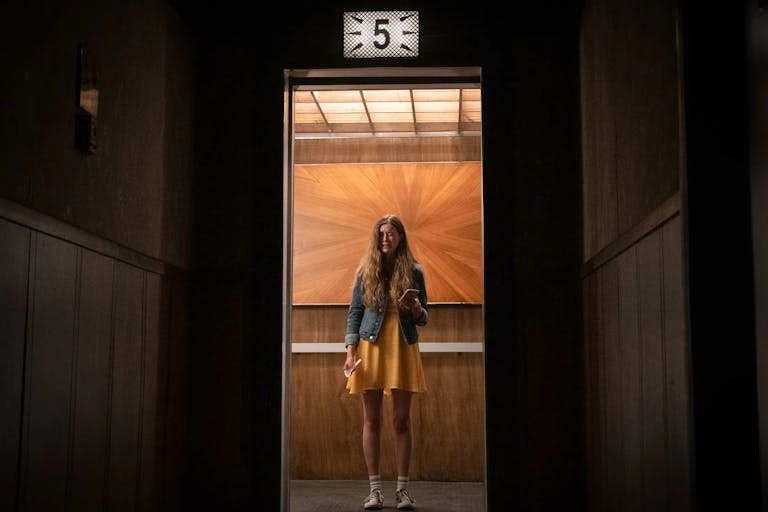 A young white girl looking terrified in a lift