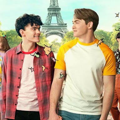 Two male teens holding hands, looking lovingly in each others' eyes, flanked by their friends with the Eiffel Tower in the background