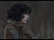 A pale woman with red lips and short wavy black hair in a dark fur coat, with a serious face, looks off into the distance