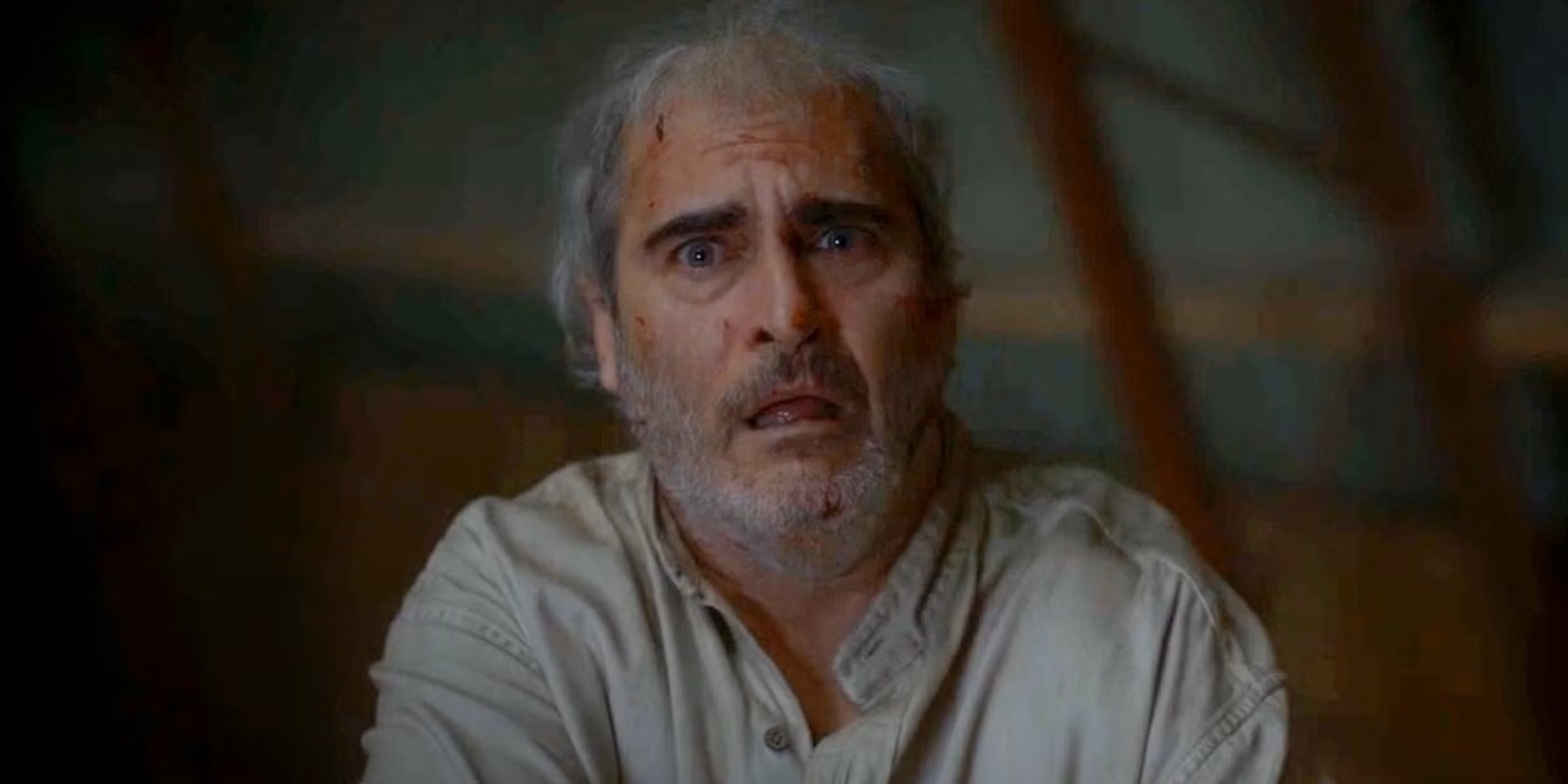 An older man with messy hair and cuts on his face, with a scared look on his face