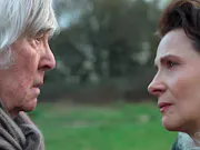 A middle aged white woman and older white man looking at eachother, with worried looks on their faces