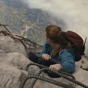 An aerial shot of a red-haired woman hanging on to the edge of a mountain, looking down at the ground far down
