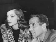 Black and white picture of a white man and woman looking towards the edge of the frame on the left
