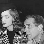 Black and white picture of a white man and woman looking towards the edge of the frame on the left