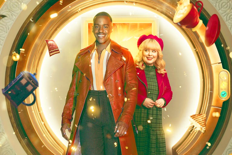 A young Black man in a long light brown leather jacket and a young white woman in a red hat and jacket standing in front of a circular door as a mug, TARDIS mug, sandwich and book fly around them