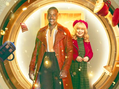 A young Black man in a long light brown leather jacket and a young white woman in a red hat and jacket standing in front of a circular door as a mug, TARDIS mug, sandwich and book fly around them