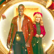 A young Black man in a long light brown leather jacket and a young white woman in a red hat and jacket standing in front of a circular door as a mug, TARDIS mug, sandwich and book fly around them