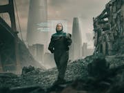 A white woman in dark clothes walking through an industrial apocalyptic wasteland with green descriptive text beside her face as if scanned
