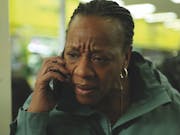 A middle aged Black woman on mobile phone looking distressed