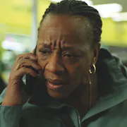 A middle aged Black woman on mobile phone looking distressed