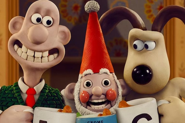 Stop motion plasticine characters, a bald white man with a large teethy smile and a beige and brown dog looking suspicious with an uncanny, overly smiley gnome between them