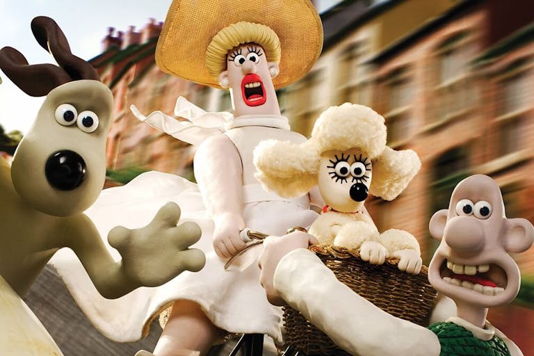 Stop motion animation of a plasticine beige dog, white woman in white red, small whit poodle dog and a white bald man trying to stop the woman from flying off down the hill on her bike