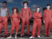 Five people in orange uniforms staring at the camera