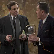 Two middle aged white man in smart suits holding an early 20th Century microphone