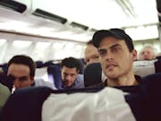 A young man on an airplane looking distressed
