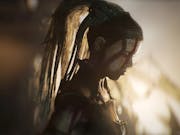 Gameplay of a barbaric woman warrior with face painted white and red war paint looking menacing