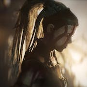 Gameplay of a barbaric woman warrior with face painted white and red war paint looking menacing