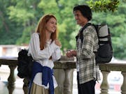 A white teen girl with red hair smiling widely with a brown teen boy