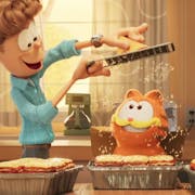 Colourful CGI animation of a white man grating cheese over a three trays of lasagne while an orange cat and yellow dog look on in delight
