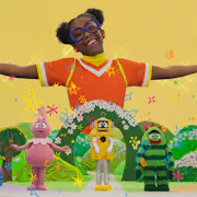 A young Black girl with hair puffs and glasses arms joyfully outstretched in a colourful fantasy land with five wacky monster characters in below