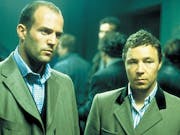 Two white men in smart woollen suits looking serious