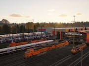 A train depot with a number of orange trains ready to leave the station. In the background, the sun is setting behind green tree-covered hills