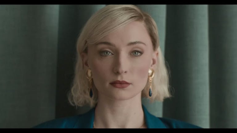 Close up of a young white woman with blonde bob, gold earrings and red lips