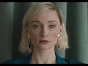 Close up of a young white woman with blonde bob, gold earrings and red lips