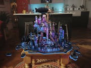 VR gameplay of a small purple-lit futuristic built-up cityscape projected onto a real life living room coffee table