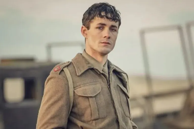 A young white male solider of WWII standing looking haunted