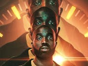A Black man with a shaved head and beard looks down the camera, his image is repeated and enlarged behind him with an orange clock face encircling him