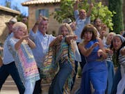 A group of people in Greece pointing and dancing