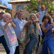 A group of people in Greece pointing and dancing