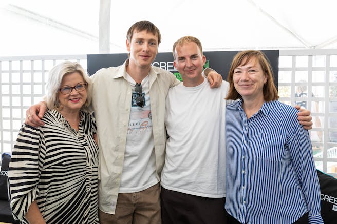 a women, two men, and another women to their right pose for a group photo