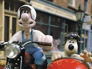 Stop motion animation of a white man on a motorcycle and a dog sitting in a red sidecar