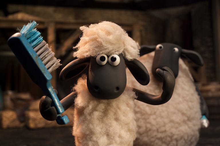 Stop motion claymation of a lamb using a brush to comb his hair with a bigger sheep behind him