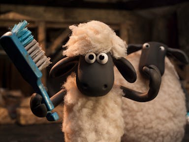Stop motion claymation of a lamb using a brush to comb his hair with a bigger sheep behind him