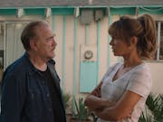 An older white man and a young white woman talking looking concerned