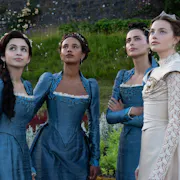 Four young women, three in blue elegant regency dresses and one in an ivory wedding dress