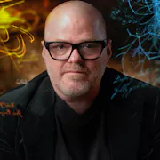 A middle aged bald white man with black framed glasses looks down the camera as neon multi-coloured lines and text swirl around him